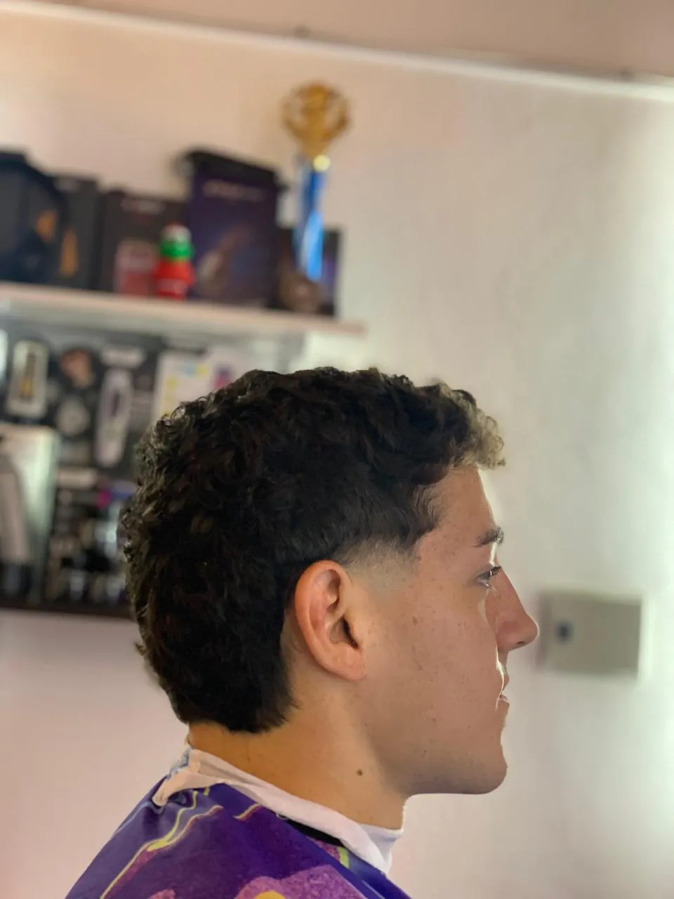 Corte rizado con puntas decoloradas y fade